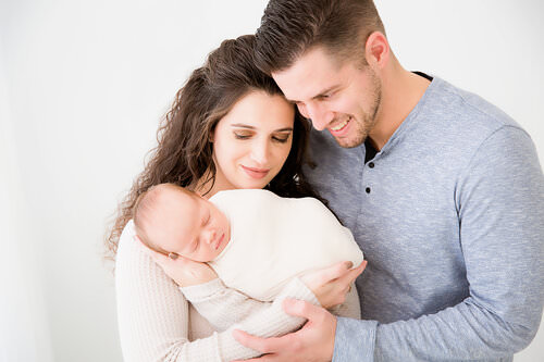 mom and dad hugging in newborn session