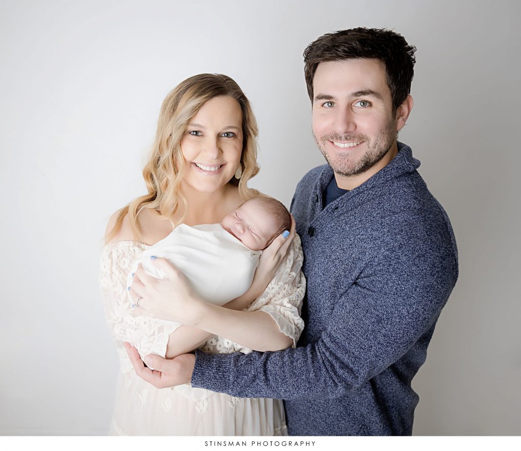 Mom and Dad holding their newborn son at their newborn photo shoot