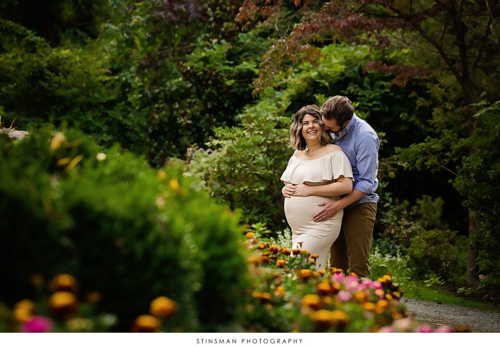 Pregnant mom and dad smiling at their maternity shoot