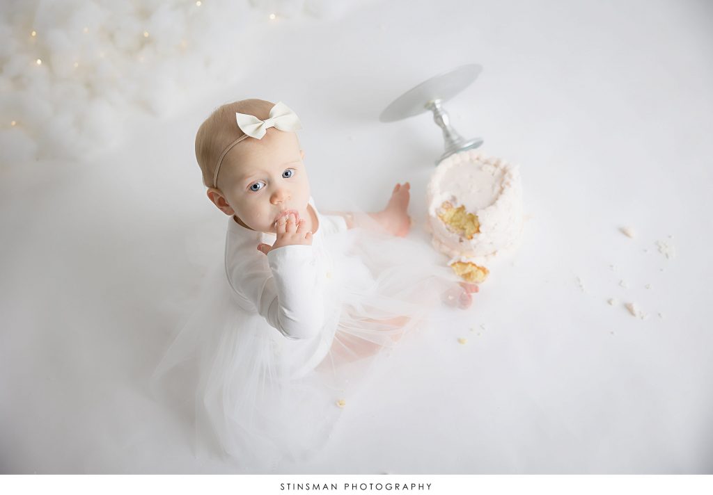 Baby girl tasting her cake at her cake smash photoshoot