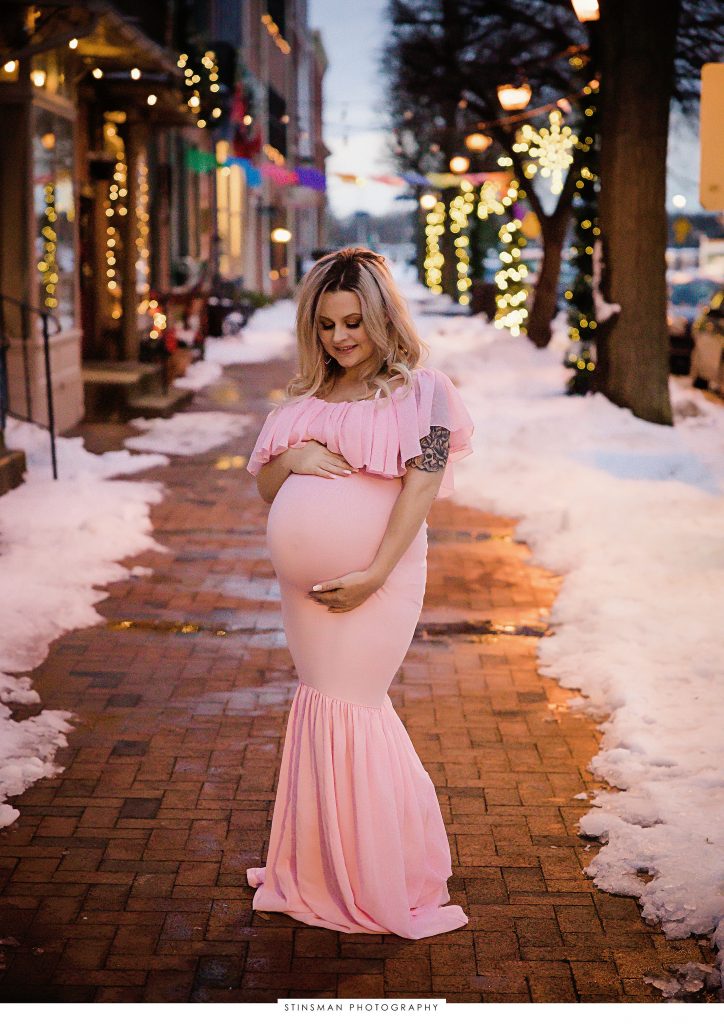 Pregnant mom in a pink dress during winter maternity shoot.