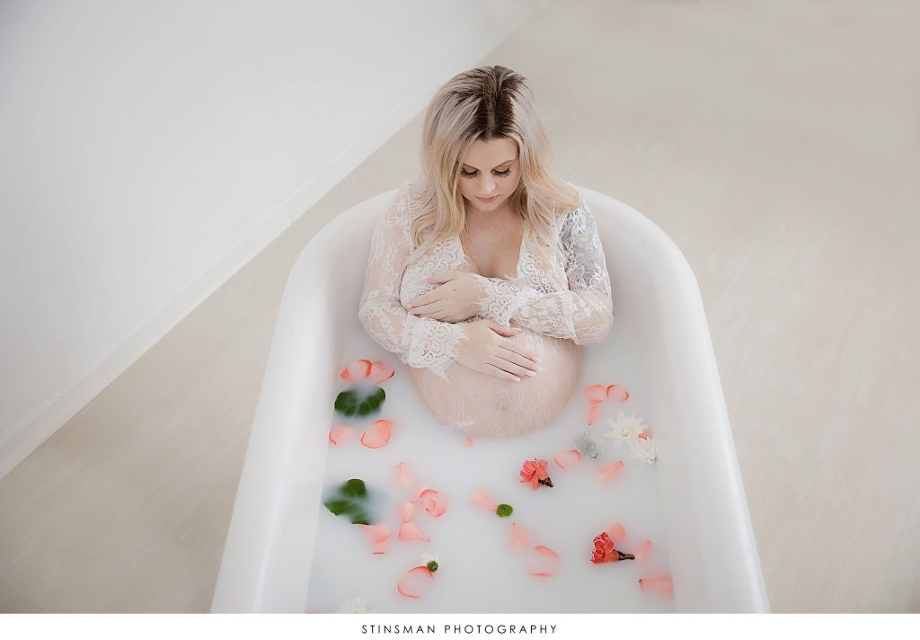 Pregnant mother in white lace during milk bath maternity photoshoot