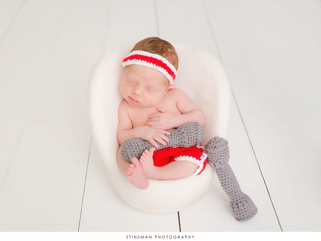 Newborn baby boy asleep in fitness outfit at his newborn photoshoot