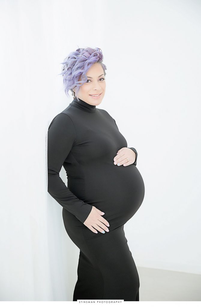 Pregnant mom smiling and posing at her maternity photoshoot