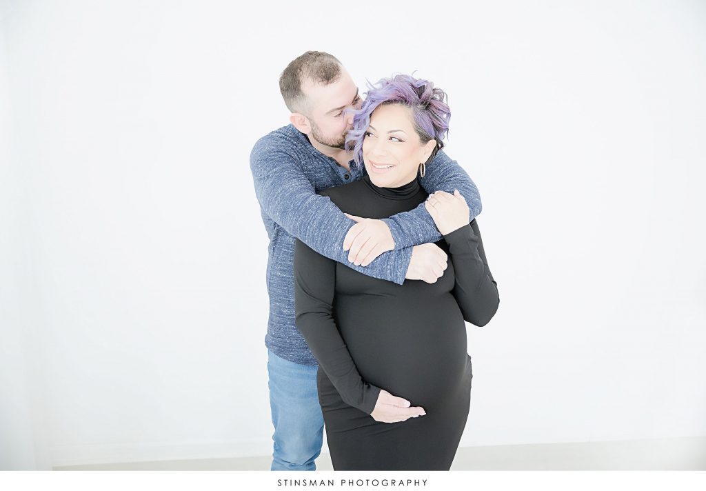 Pregnant mom and dad snuggling at their maternity photoshoot