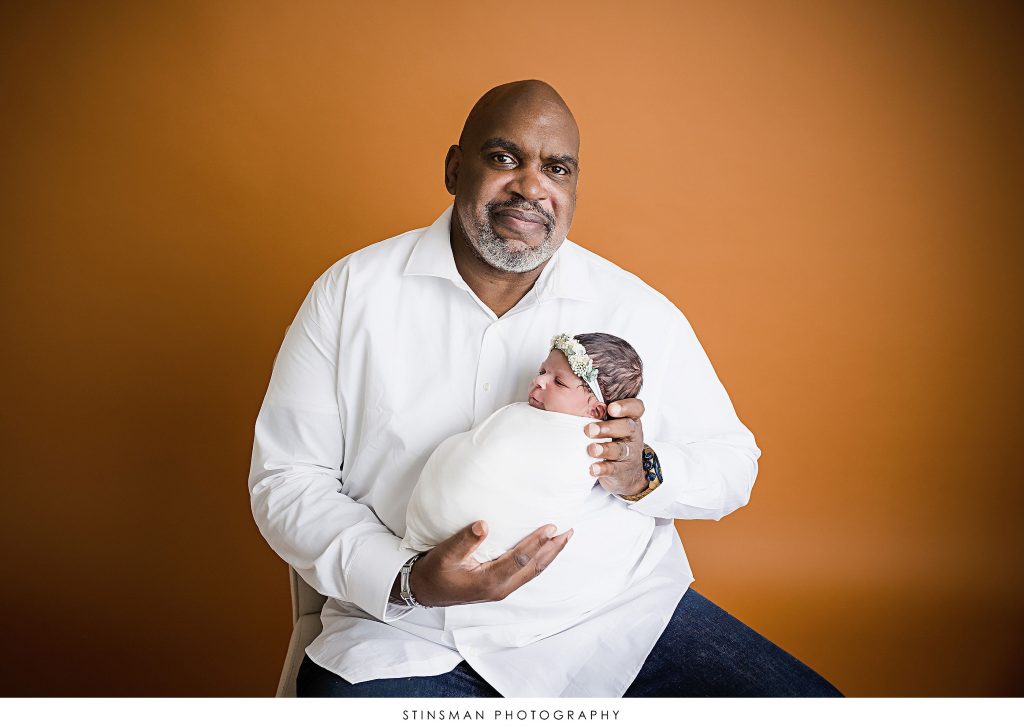 Dad snuggling his baby girl at their newborn photoshoot