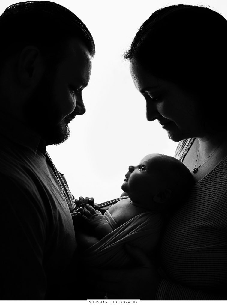 Mom and dad posed with their newborn son at their newborn photoshoot