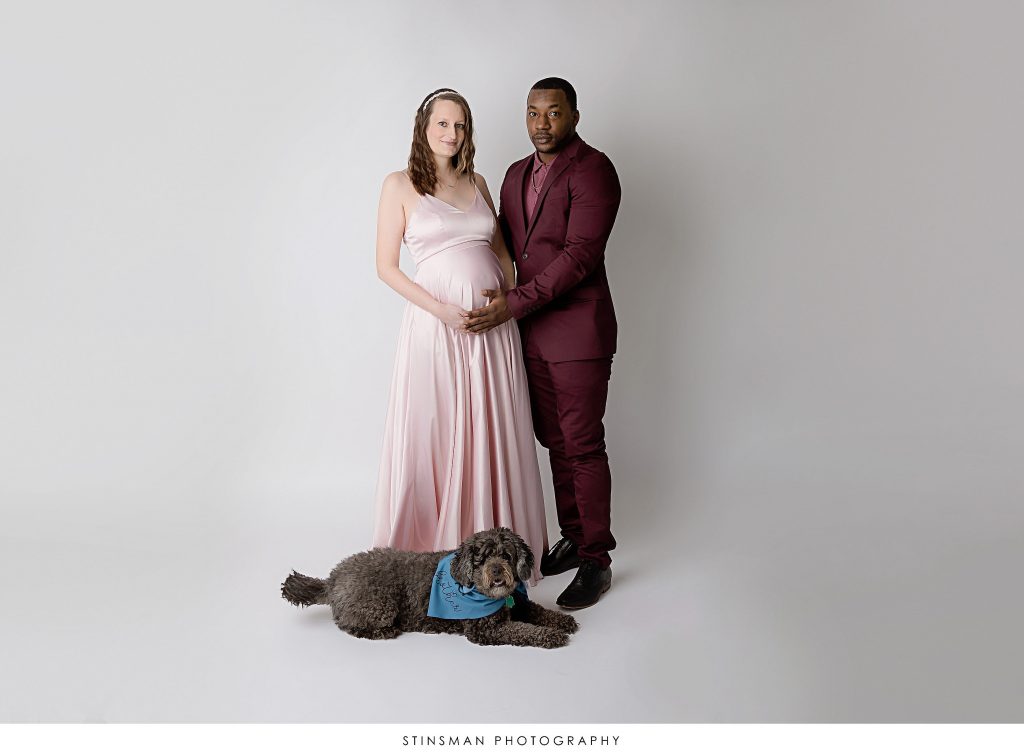 Pregnant mom and dad to be with their dog posing at their maternity photoshoot