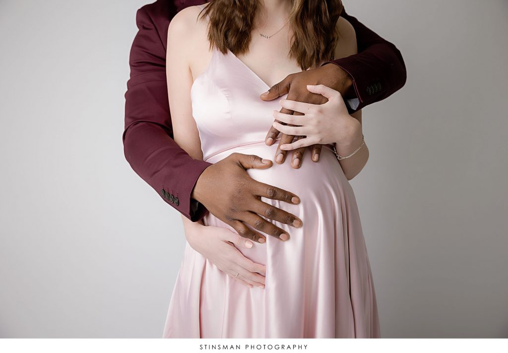 Pregnant mom and dad holding the baby bump at their maternity photoshoot