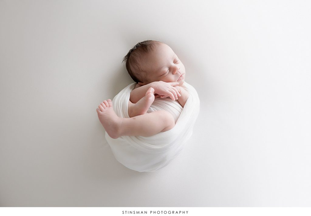 Newborn baby girl asleep and posed at her newborn photoshoot