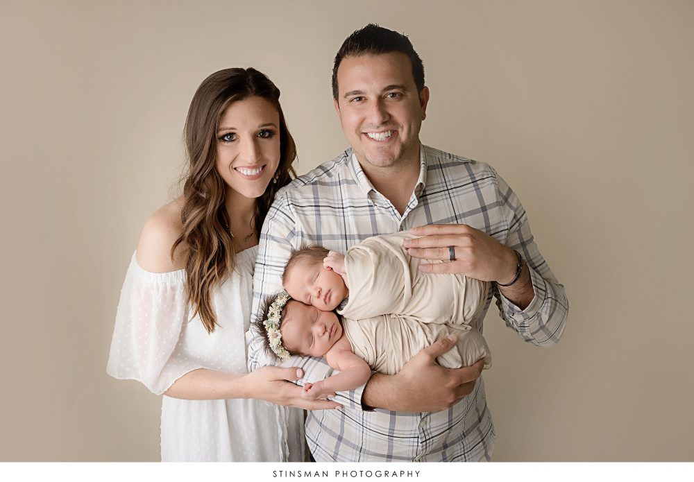 Mom and dad posed with their twins at their newborn photoshoot