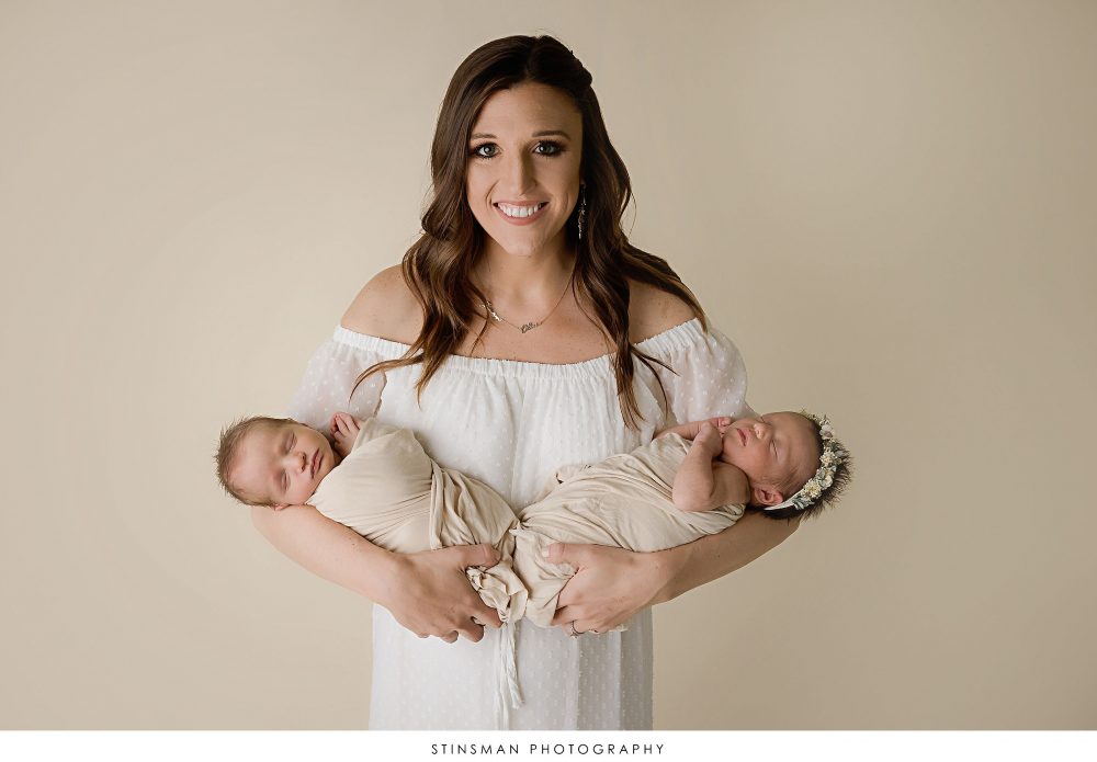 Mom holding newborn twins at their newborn photoshoot