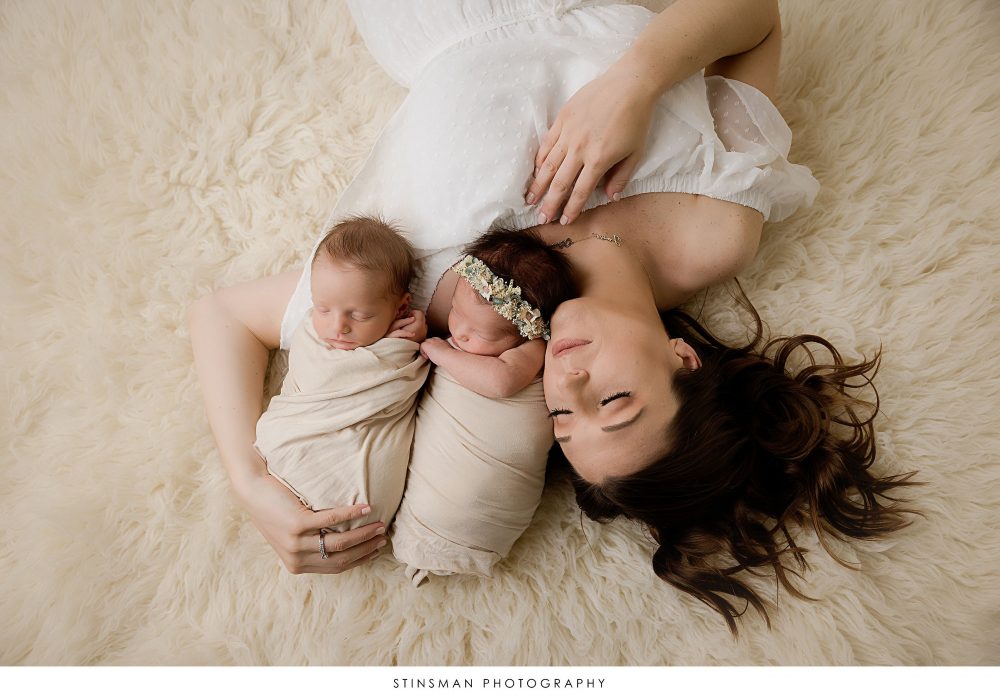 Mom posing with her twins at their newborn photoshoot