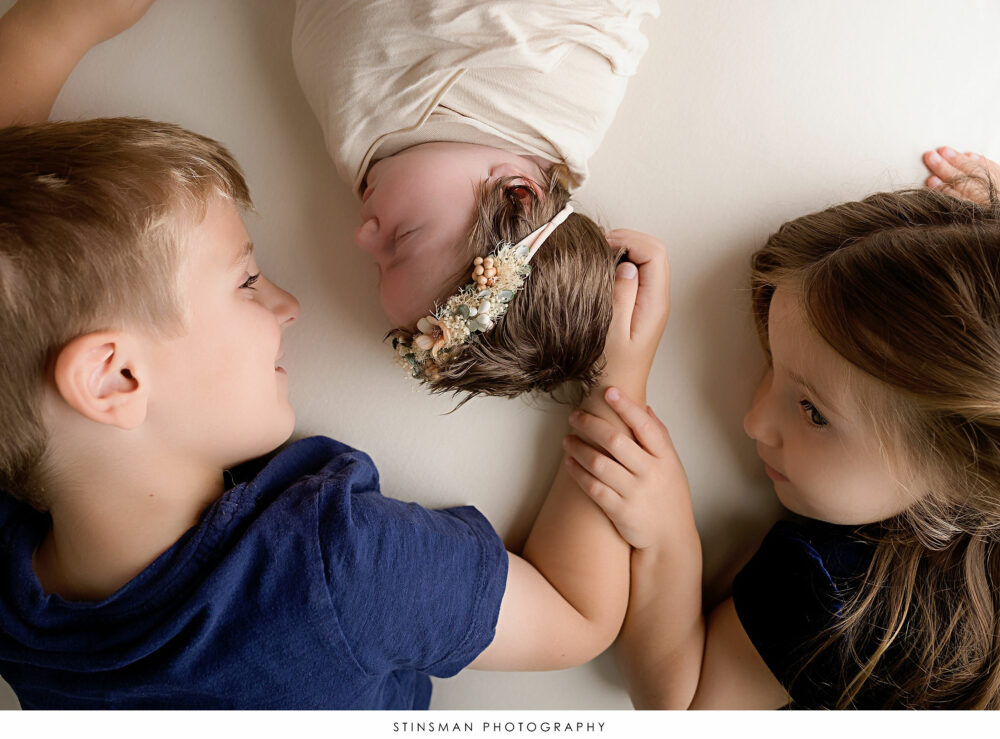 Newborn baby girl and her older siblings posed at her newborn photoshoot