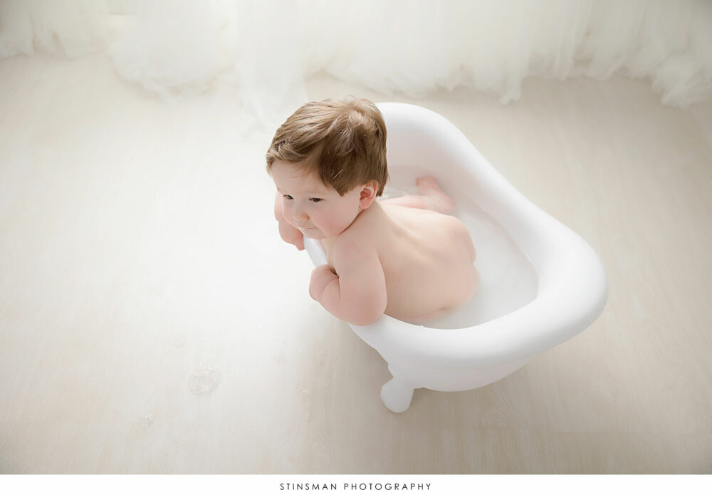 One year old boy posing in the tub at his milestone photoshoot