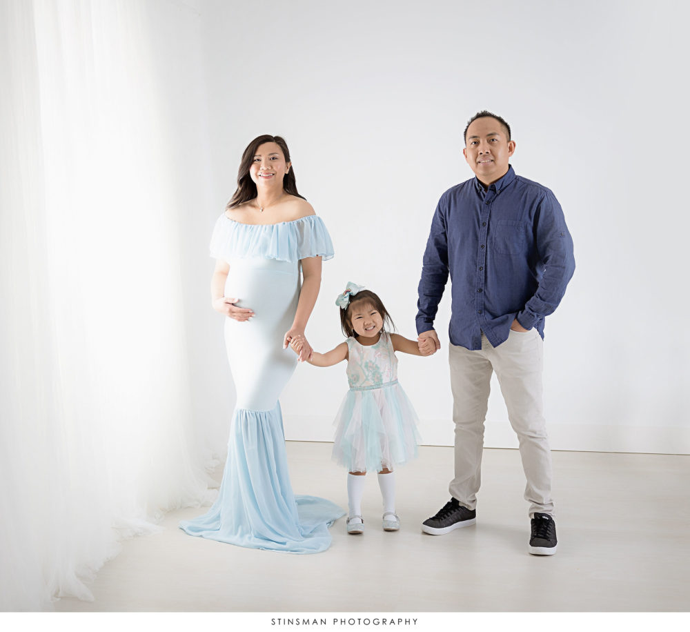 Pregnant mom posing with her family at her maternity photoshoot