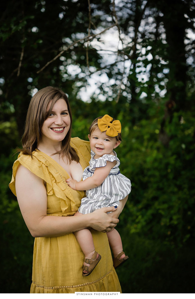 mom and baby girl smiling at milestone photoshoot