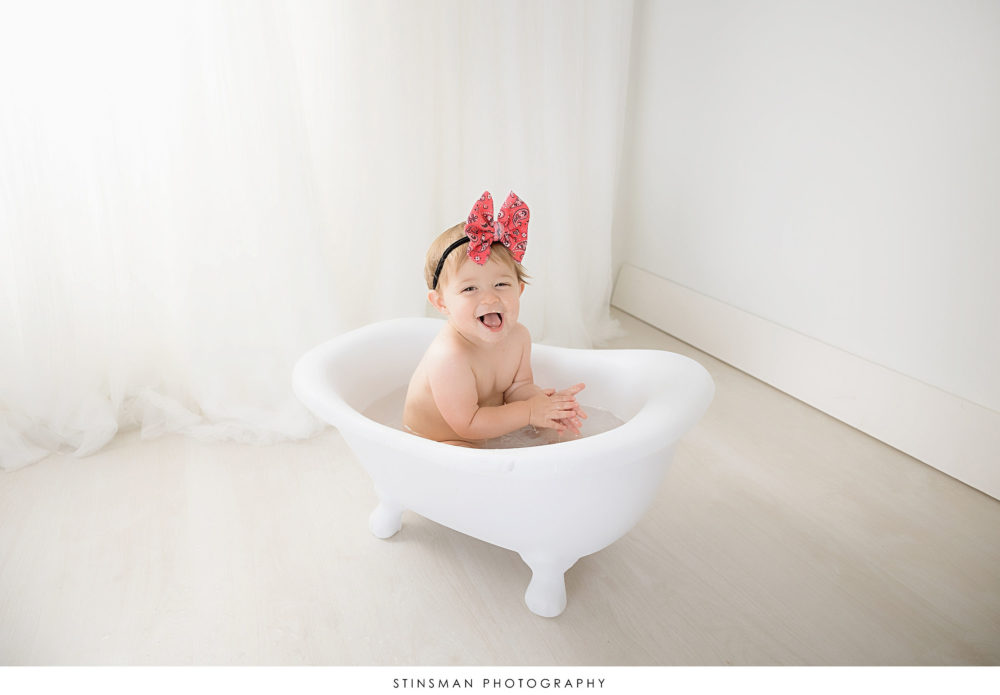 One year old posing in a tub at her milestone photoshoot