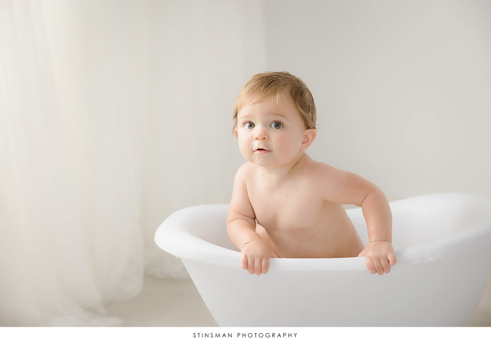 One year old girl in a tub at her milestone photoshoot