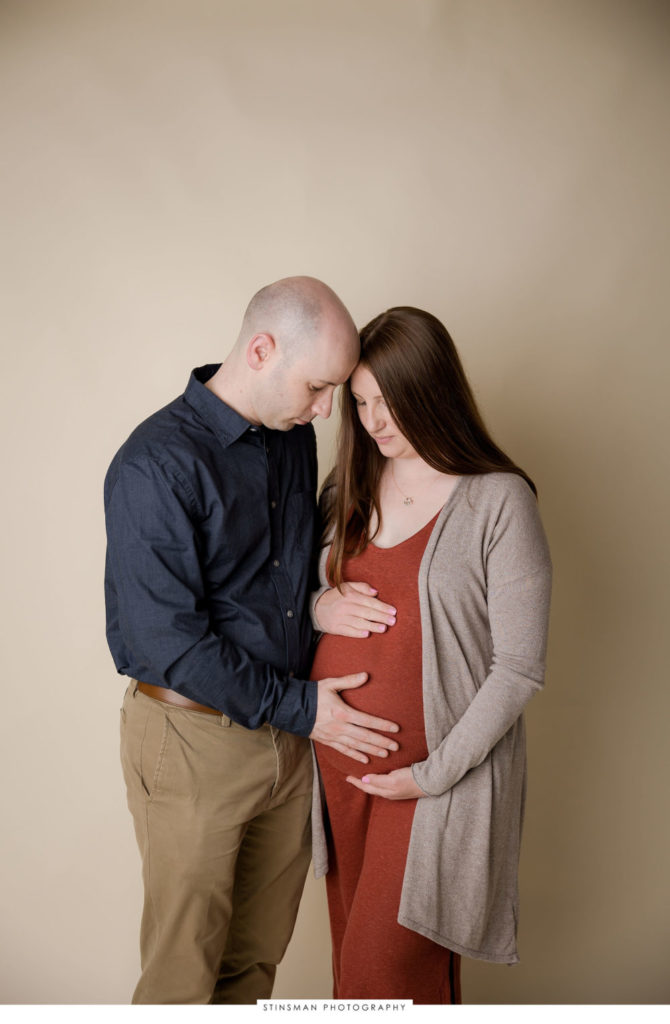 Pregnant mom and dad posing at their maternity photoshoot