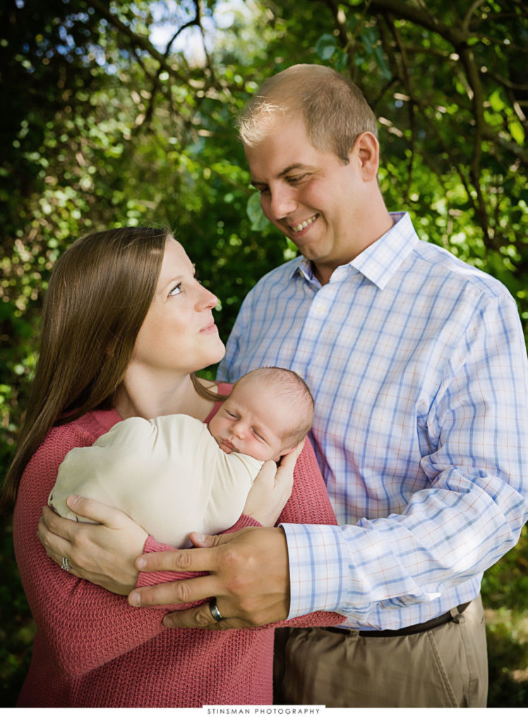 Parents snuggling their newborn baby boy at newborn photoshoot