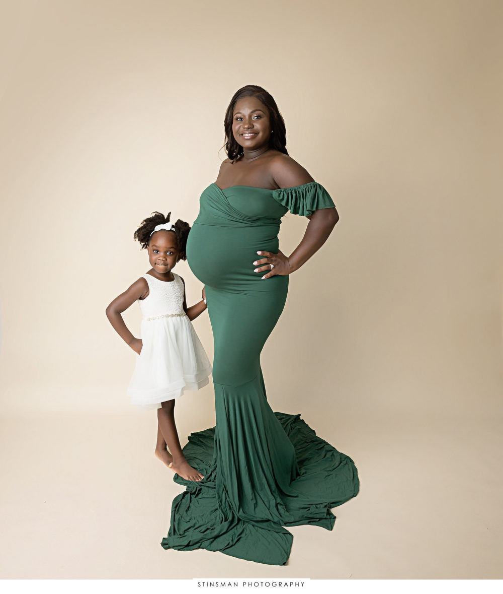 Pregnant mom and her daughter posing at her maternity photoshoot