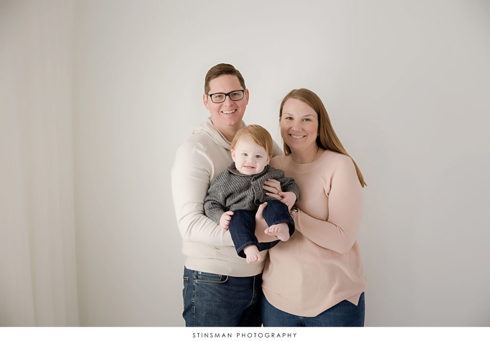 Parents posing with their one year old boy at their milestone photoshoot