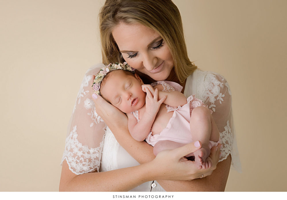 Newborn baby girl posed with her mom at her newborn photoshoot