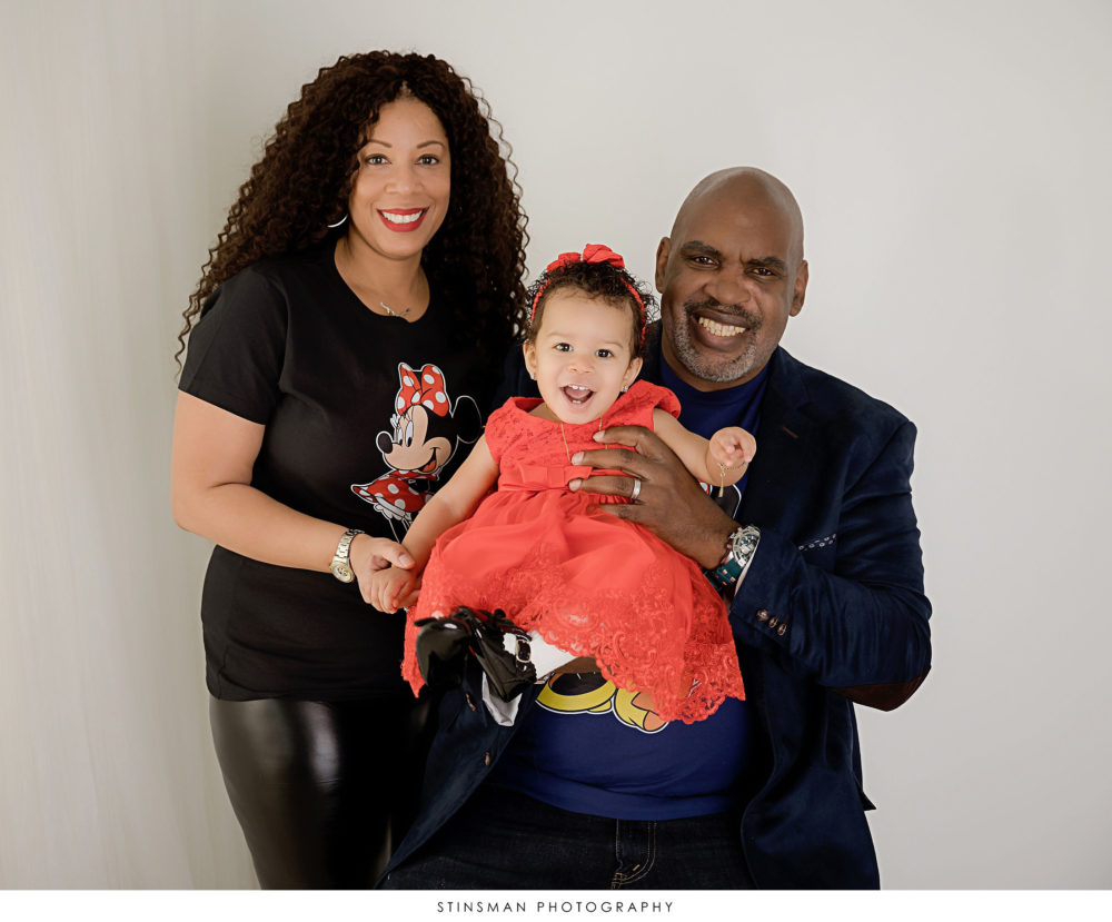 Mom and dad posing with their little girl at their first birthday milestone photoshoot