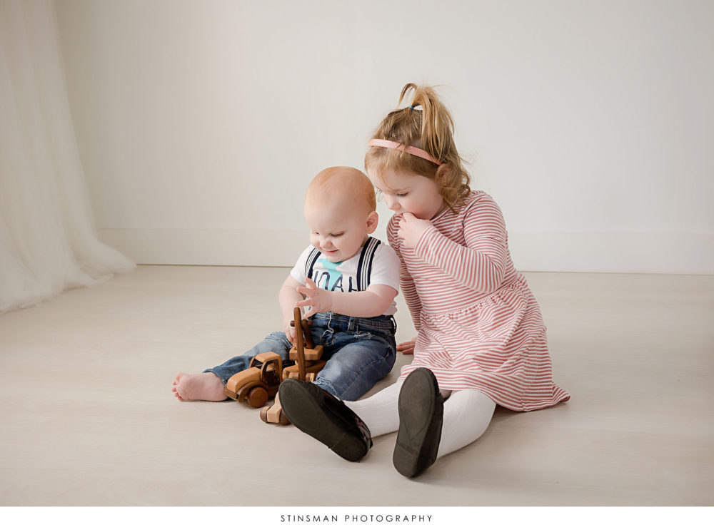 One year old boy and his sister posed at his milestone photoshoot