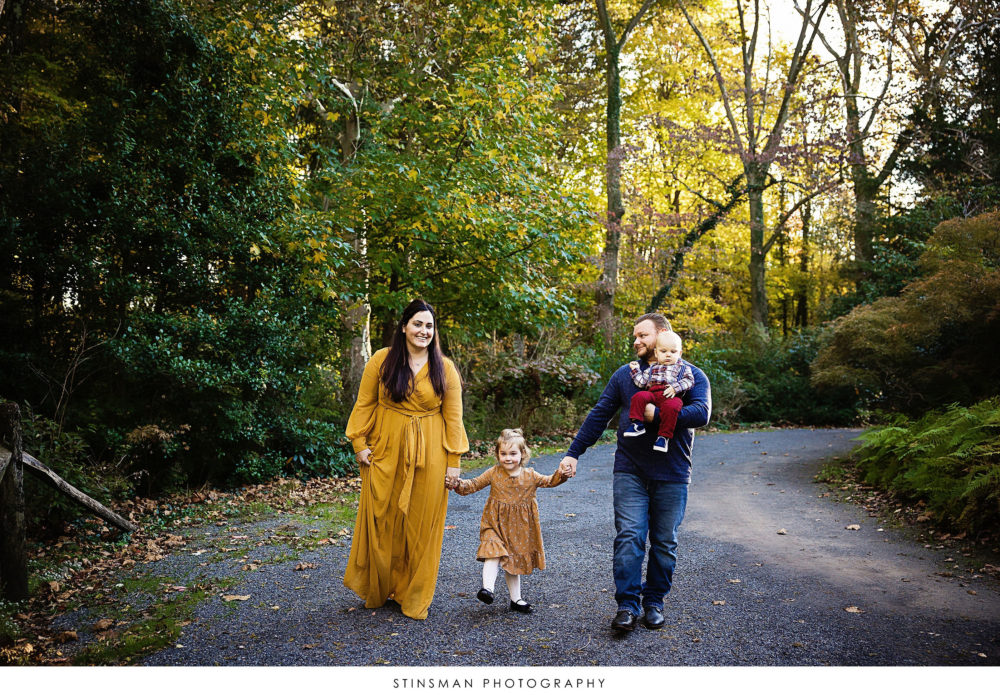 Family walking down a road at their outdoor family photoshoot