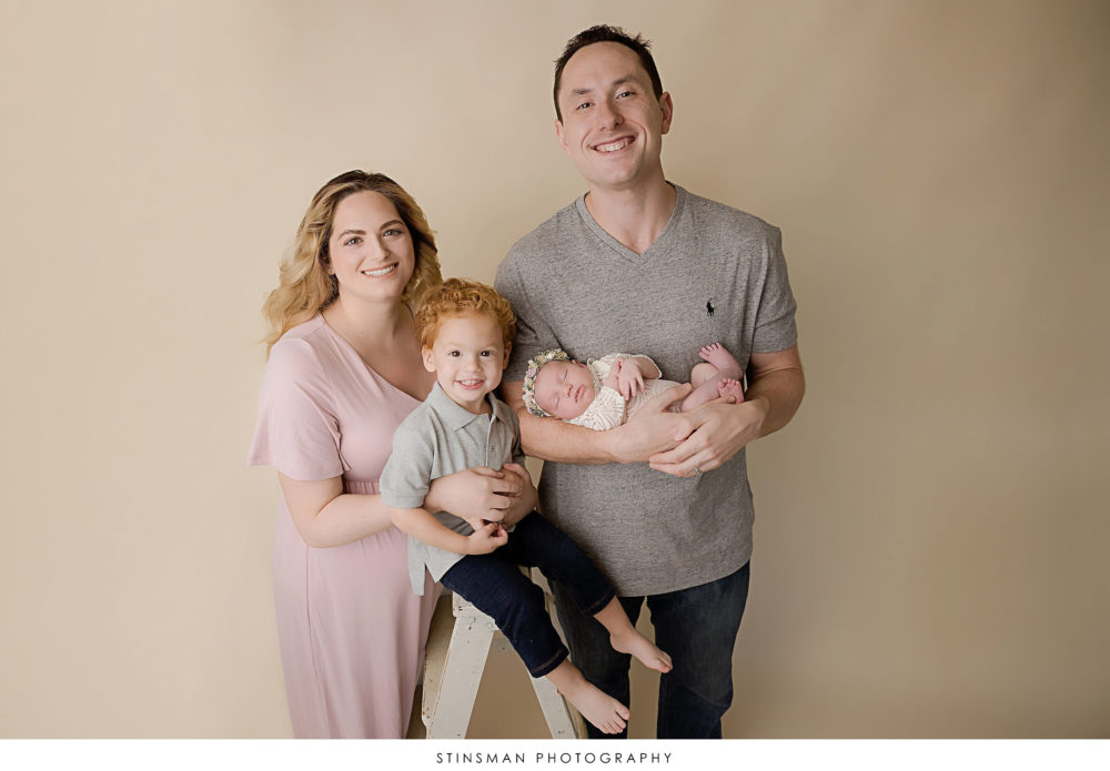 Newborn baby girl posed with her family at newborn photoshoot