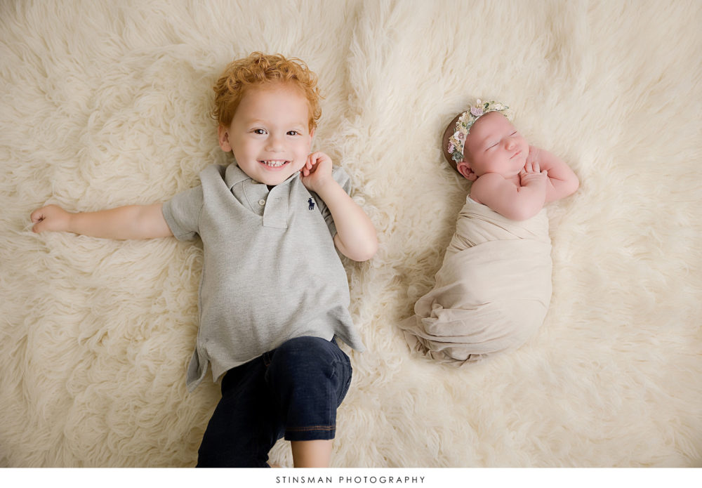 Newborn baby girl posed with her brother at her newborn photoshoot