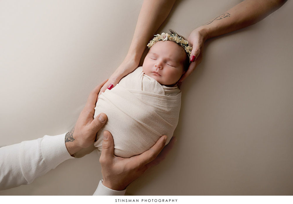 Newborn baby girl held by mom and dad for first in-studio photo shoot