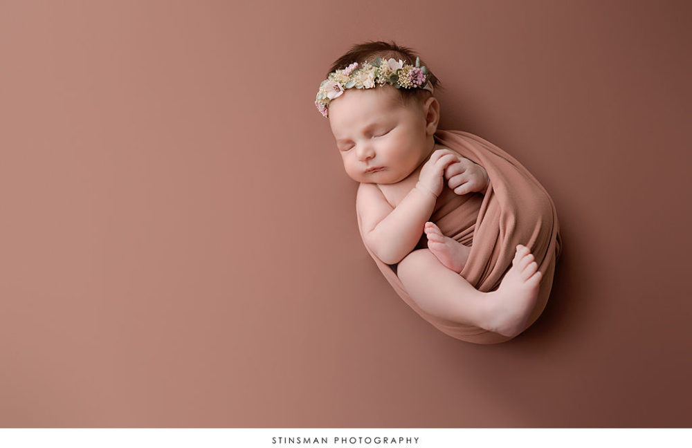 sleeping baby girl partially swaddled for newborn photo shoot in south jersey