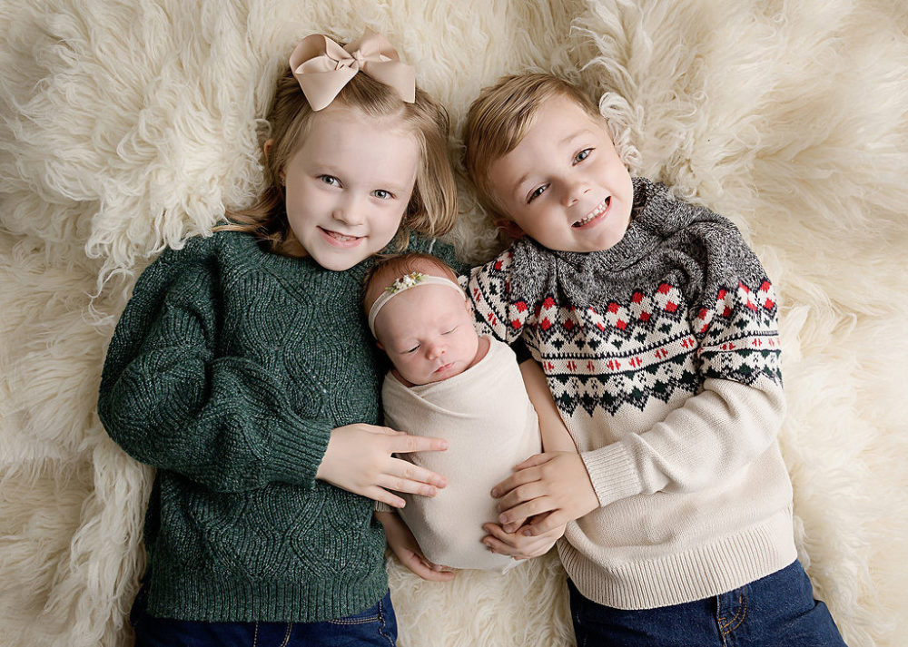 young brother and sister with newborn baby in middle for in-studio photography in Central Jersey.