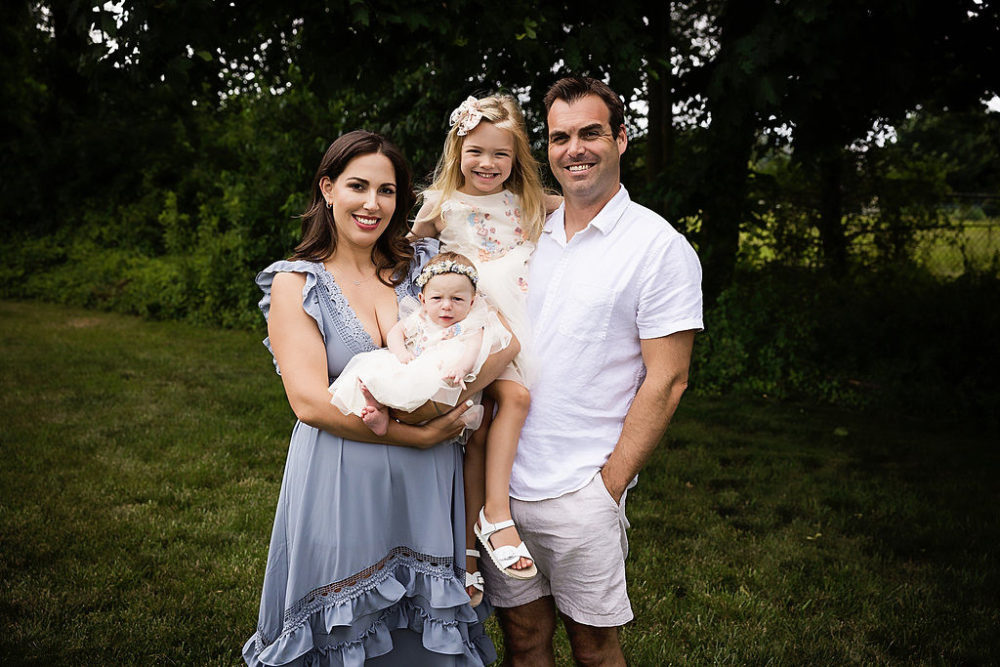 Family of 4 with nature background for first family portrait at park in South New Jersey