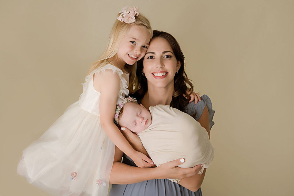 Mom holding 6 month baby with daughter in cream colors for newborn photoshoot in south New Jersey.
