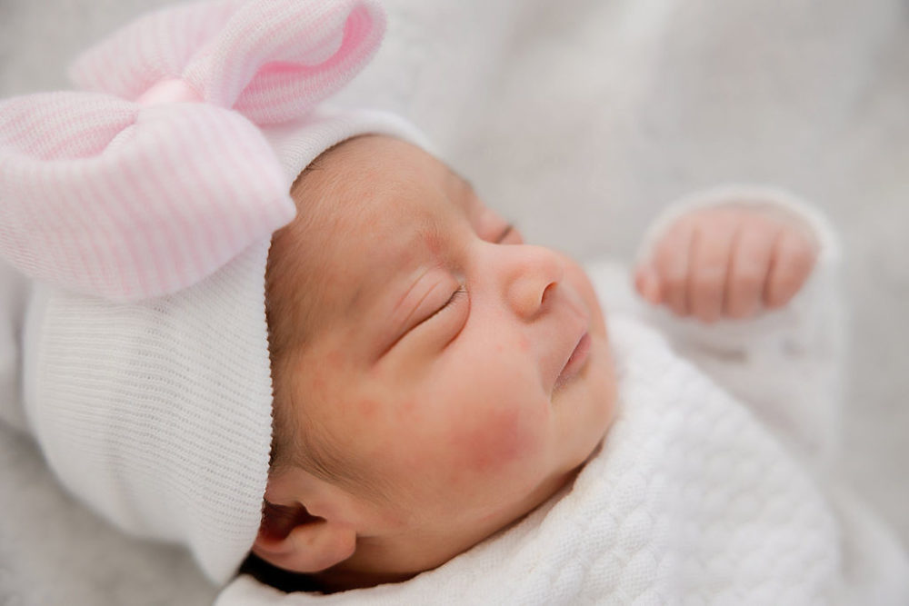 Newborn photography of girl wearing bow for in-home newborn session in central New Jersey