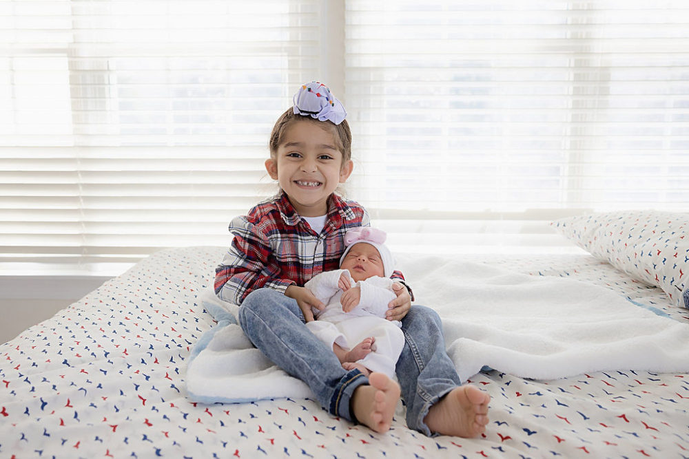 young boy holding baby sister for her in-home newborn session in Southampton, New Jersey