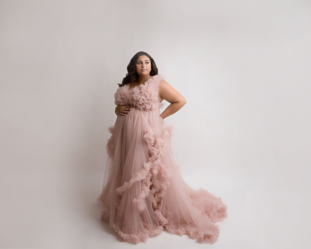 Mom in ruffly dress for her pop of pink in-studio maternity session in Camden, New Jersey.