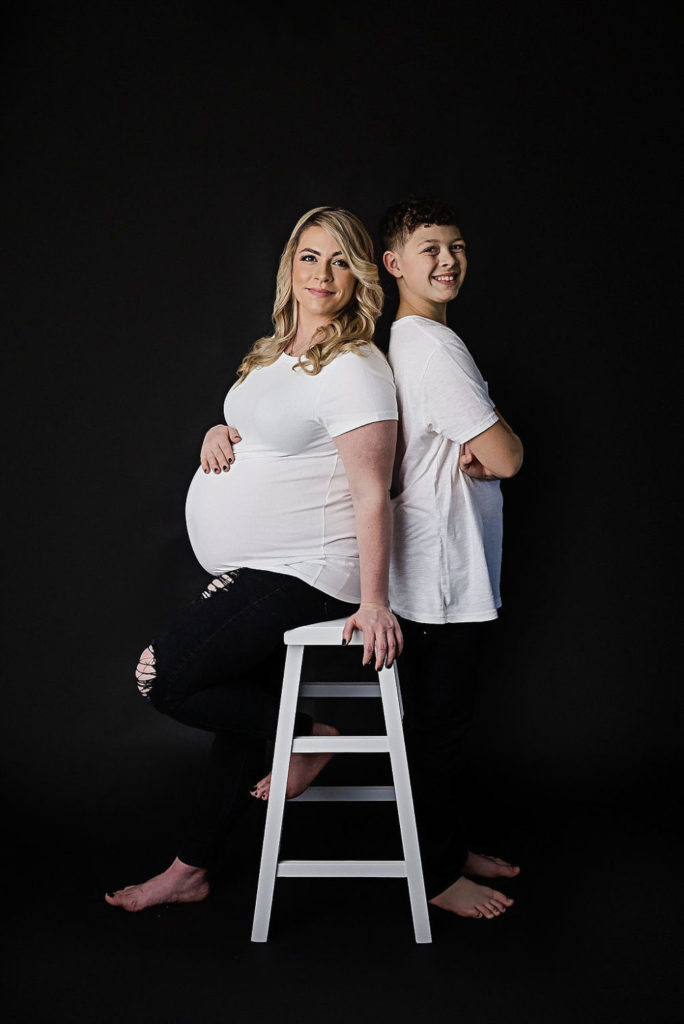 Mother and son wearing matching outfits for her black-and-white maternity and newborn session in Jersey City, New Jersey.