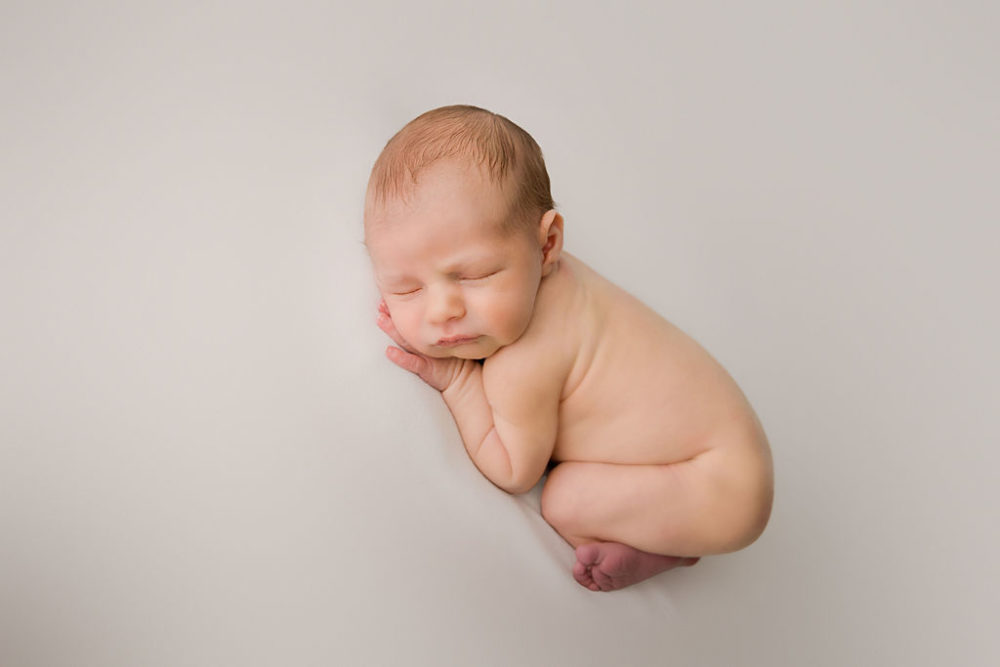 Newborn boy in sleepy pose for his first baby portraits in Princeton, New Jersey.