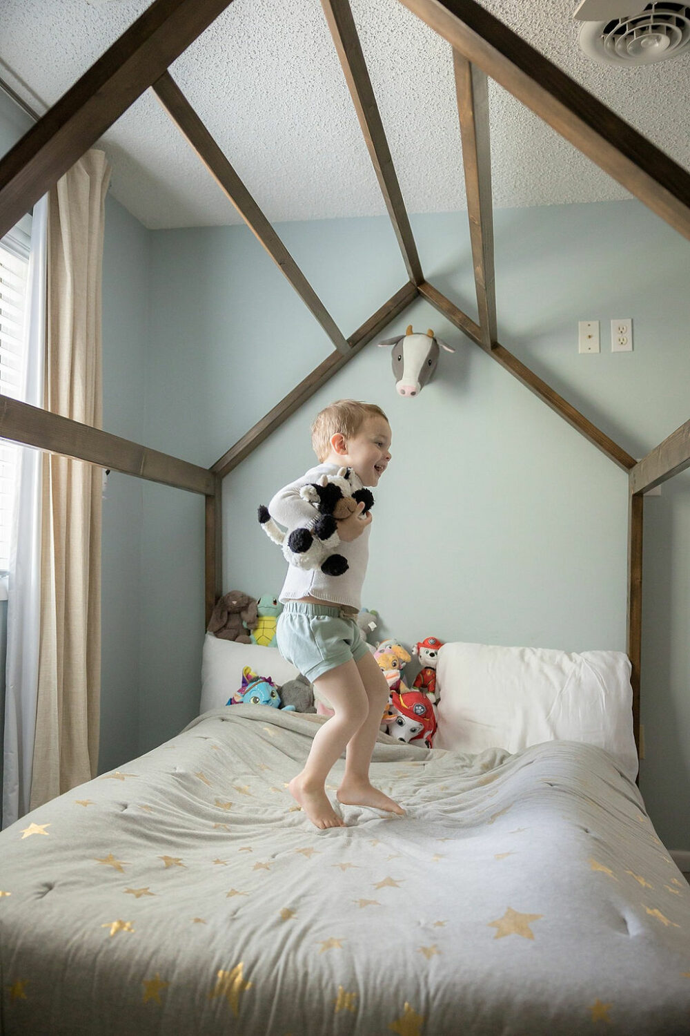 young boy smiling while jumping mid-air for in-home lifestyle family session in Voorhees, New Jersey.