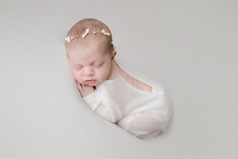 Newborn girl sleeping on chest wearing infant outfit for newborn photography session Mount Holly, New Jersey