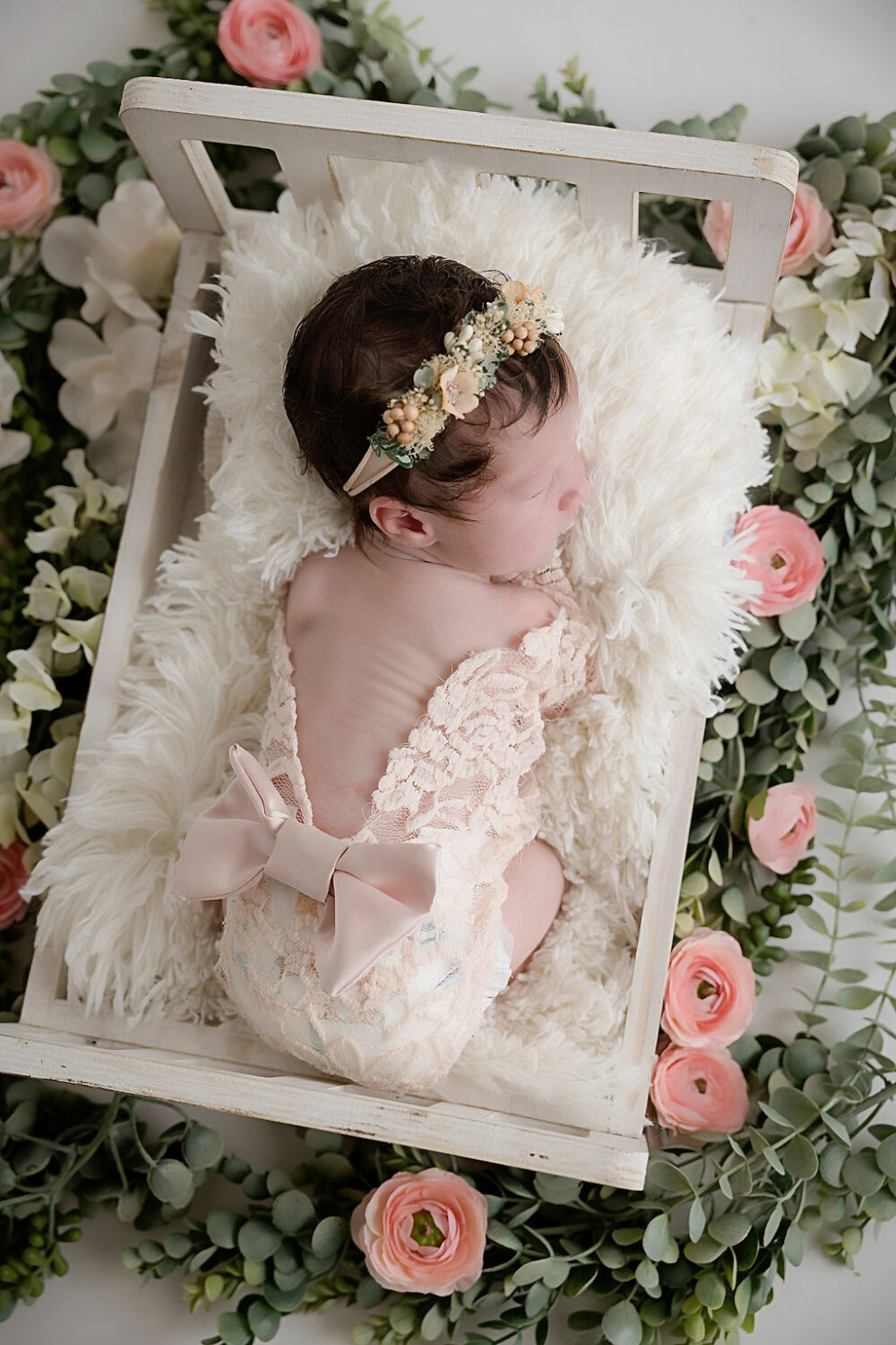 Newborn girl sleeping on baby photography props for her famous portrait photographers in Moorestown, New Jersey.