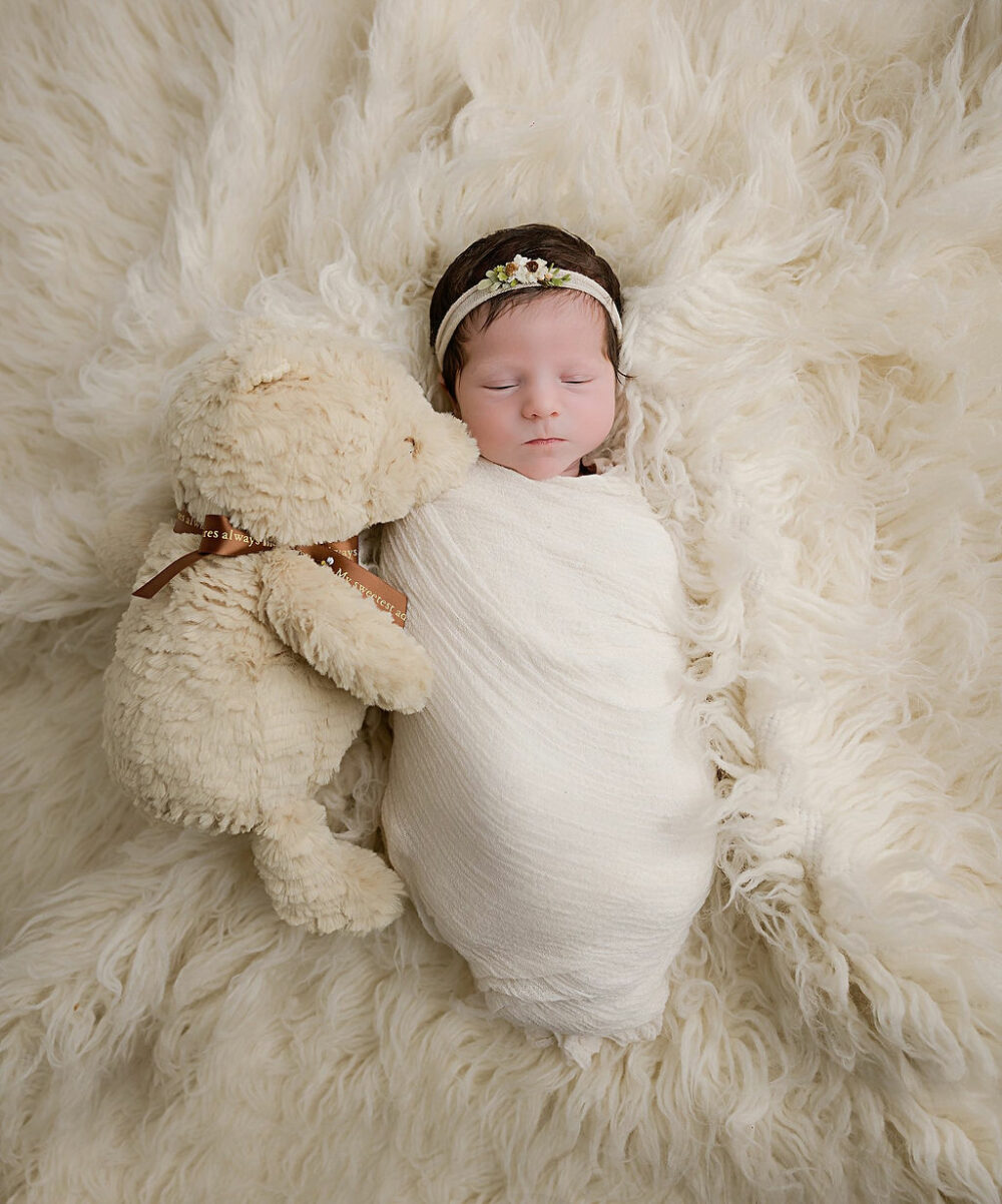 Newborn baby Portrait of girl wrapped in swaddle on newborn photography blankets for her in studio newborn session in Medford, New Jersey.