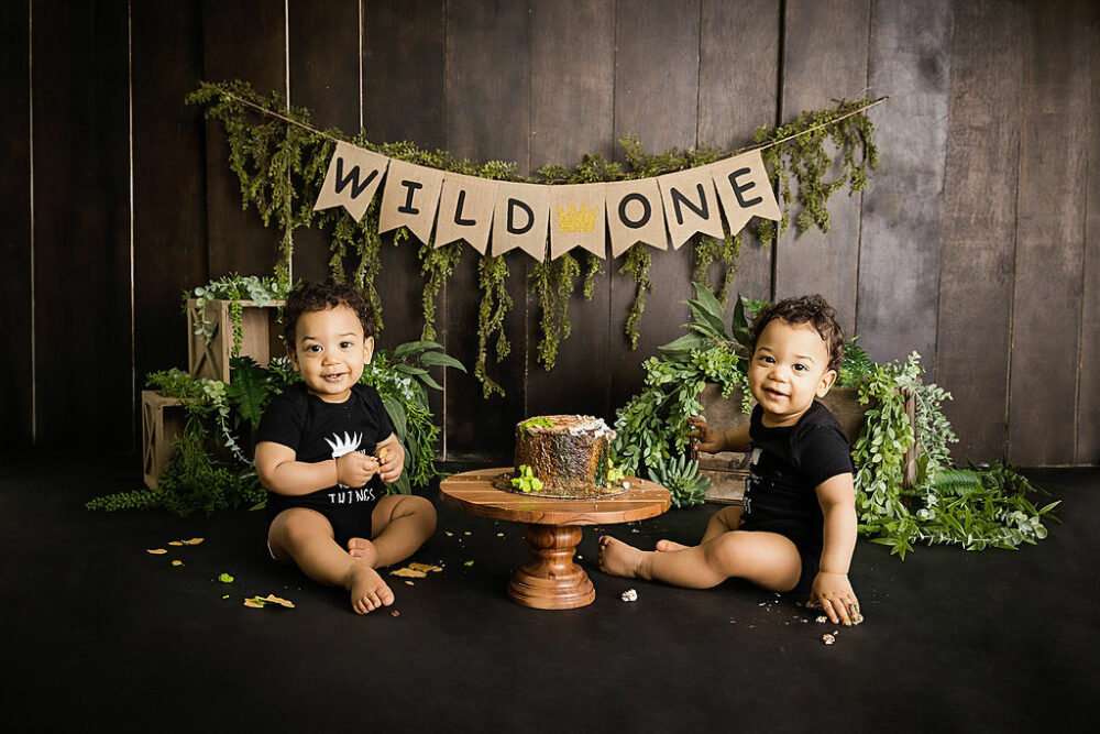 Twin brothers smiling at camera for their Wild one first birthday session in Princeton, New Jersey.