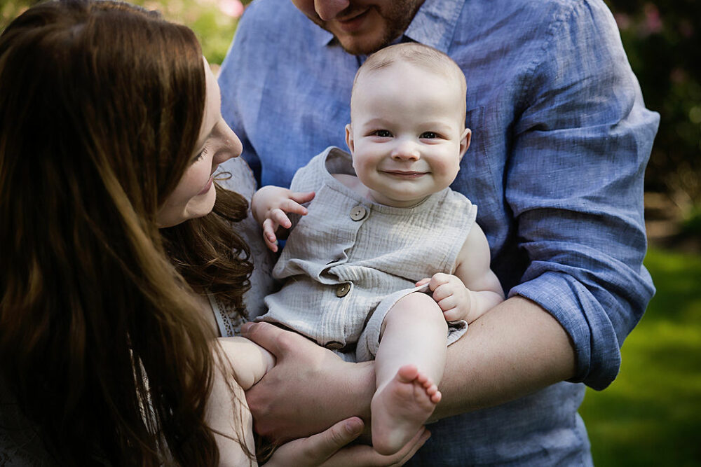Baby boy smiling at camera for a summer fun outdoor family session in Princeton, New Jersey.