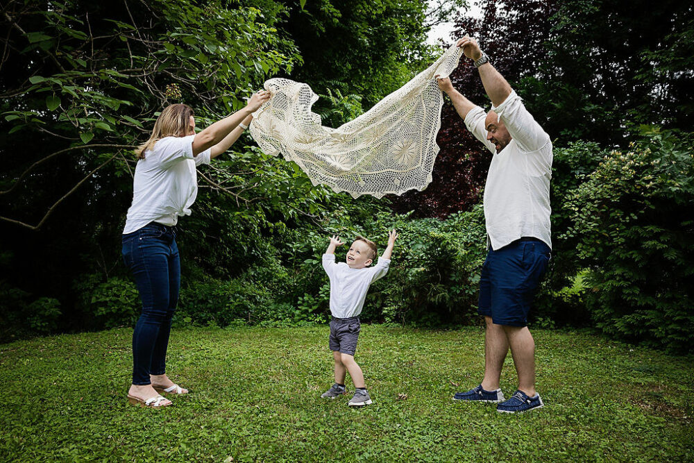 Mom and dad, Cassie blanket up for their toddler, son and backyard for their family group photo taken in Pemberton, New Jersey.
